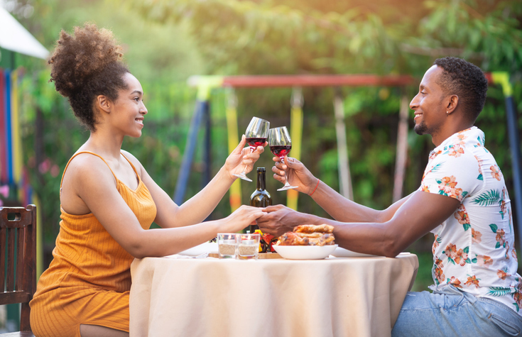 Afro Couple having staycation romantic dinner on back yard, during COVID-19